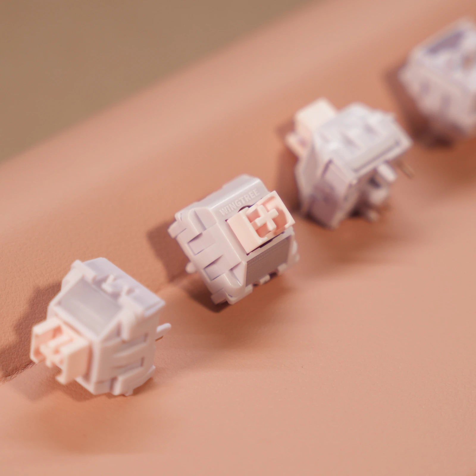 Purple keyboard switch shown in 4 different positions on a pink background