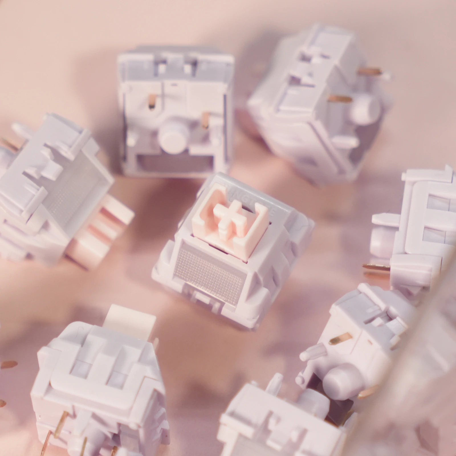 Close up of a purple mechanical keyboard switch on a pink background