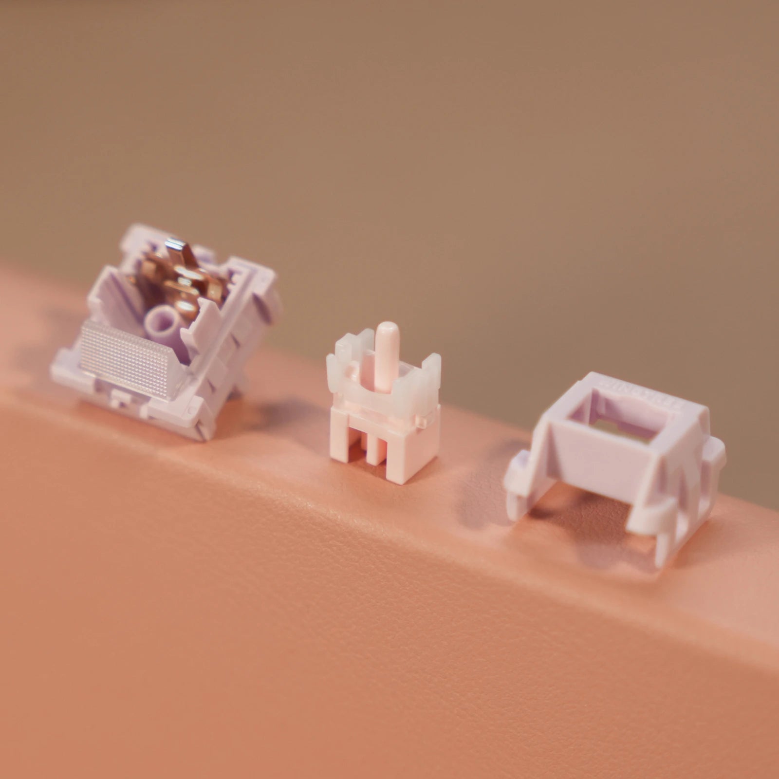 Purple mechanical keyboard switch disassembled into 3 parts